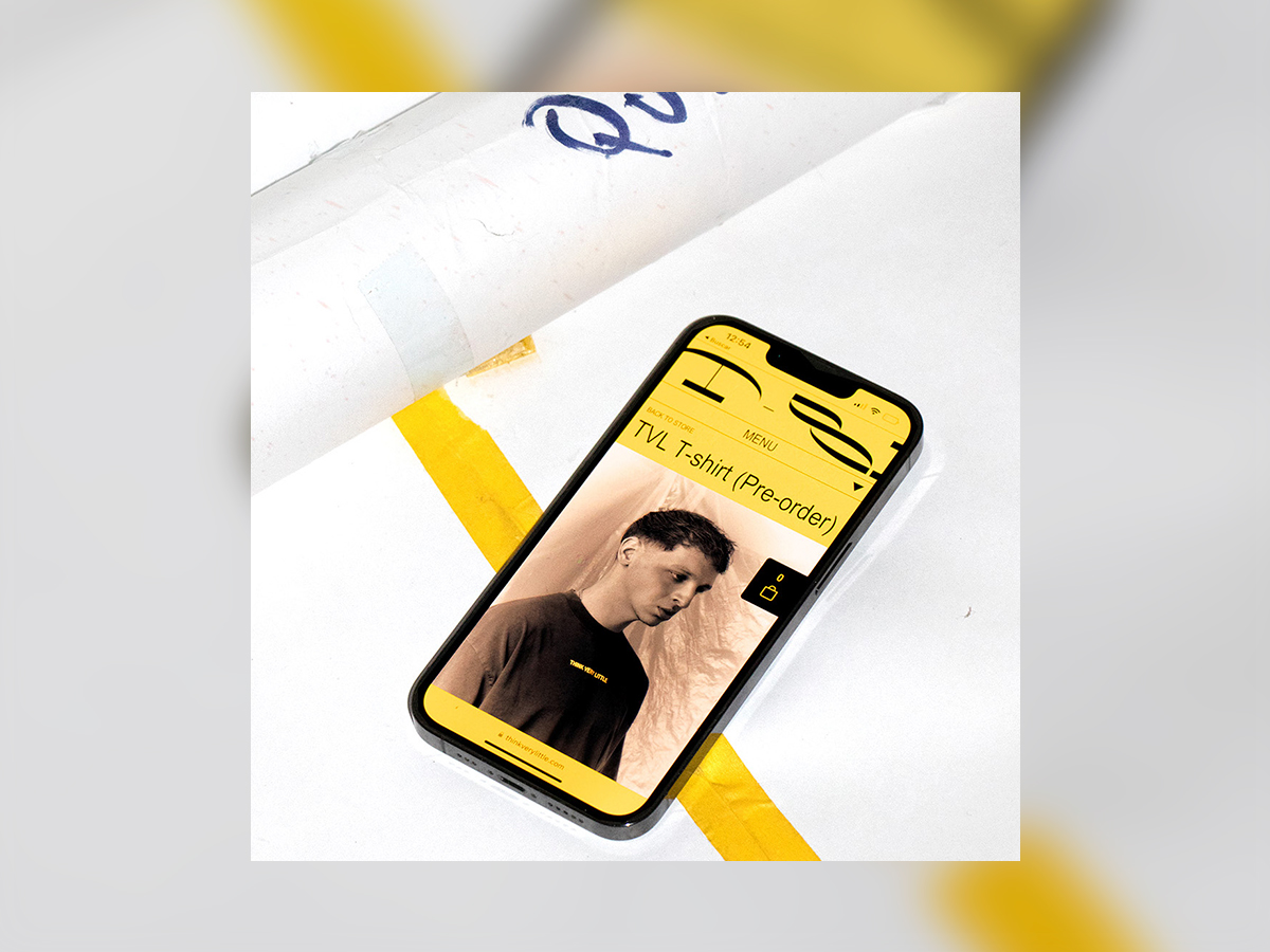 Think Very Little creative agency e-commerce website showcasing TVL T-shirt pre-order page on iPhone mobile screen